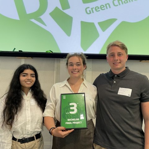 Cornell students hold us a green poster with the number "3" on it. 